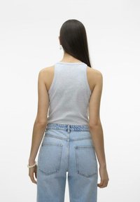 Gray sleeveless tank top with a round neckline, paired with light blue high-waisted denim jeans featuring a relaxed fit and back pockets.