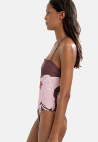 Brązowy i różowy kwiecisty jednoczęściowy strój kąpielowy o dopasowanym kroju, z ramiączkami spaghetti i gładką teksturą. Posiada duże wzory kwiatowe.