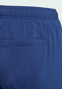 Navy blue elastic waistband shorts with a smooth texture and a single back pocket. Simple design with no visible patterns or hardware.