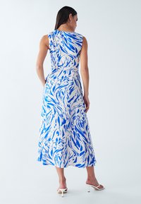 Sleeveless maxi dress in light fabric featuring a blue and white abstract pattern. Smooth texture with a flowy silhouette and ankle-length hem.