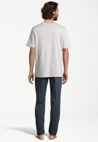 T-shirt en coton gris avec manches courtes, associé à un pantalon de pyjama rayé bleu marine comportant des lignes bleu clair. Design minimaliste ; coupe décontractée.
