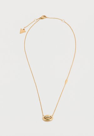 Collier délicat en chaîne d'or avec pendentif ovale orné de petits cristaux incrustés et un charm triangulaire près du fermoir sur fond blanc.