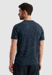 Navy blue cotton t-shirt with short sleeves, featuring a white topographic contour design on the back. Crew neck, relaxed fit.