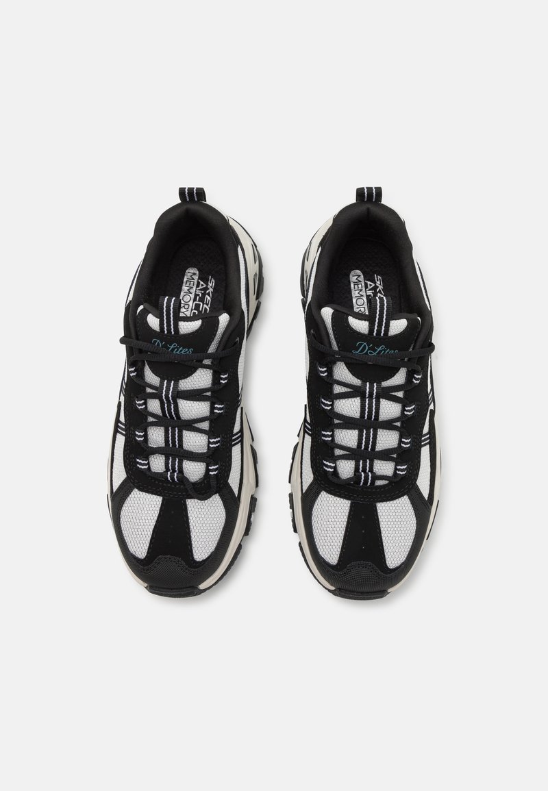 Schwarz-weiße Sportschuhe mit einem Obermaterial aus Mesh, gepolstertem Kragen, dicker Sohle und kontrastierenden Schnürsenkeln mit blauen Akzenten an der Seite.