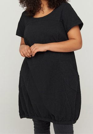 Sort tunika-top med korte ærmer, rundet halsudskæring og forlommer. Har en rynket kant for en løs pasform og tekstureret stof.