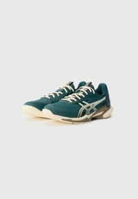 Teal athletic shoes with cream laces and accents, featuring a textured fabric upper, cushioned sole, and a supportive design for performance.