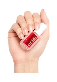 Smalto Essie in una bottiglia di vetro trasparente con un tappo bianco. Il colore dello smalto è un rosa chiaro, che mette in risalto unghie curate.