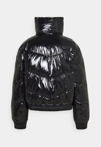 Černá péřová bunda s lesklým povrchem, vysokým límcem, chevronovým prošíváním a žebrovanými manžetami a spodním lemem. Má zkrácený siluetu.