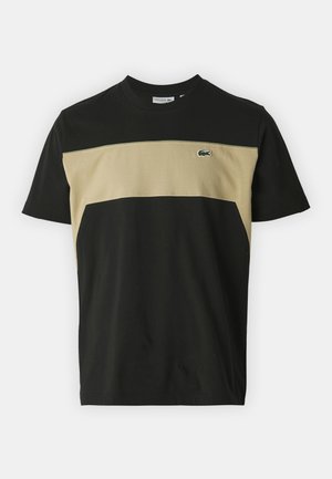 T-shirt de gola redonda com um corpo preto e um painel horizontal bege. Feito de algodão, com um pequeno logótipo verde no peito.