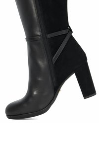 Zwarte haklaars tot de enkel met een gladde leren afwerking en een suede paneel. Bevat een zijrits en een accentriem voor extra detail.