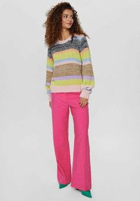 Megzta džemperis su įvairiaspalviais dryžiais: smėlio, rožinės, žalios ir lavandinės spalvos. Derinamas su ryškiai rožiniais platėjančiais džinsais ir žaliais aukštakulniais batais.