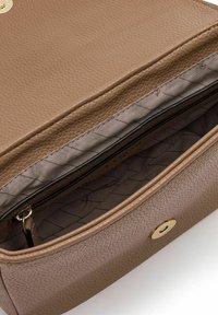 Bolso de mano de cuero marrón claro con una exterior texturizada, herrajes dorados y un bolsillo con cremallera. El interior presenta un forro de tela clara con un patrón geométrico.