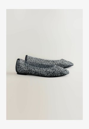 Zapatos planos negros y plateados con punta afilada, que cuentan con un upper texturizado decorado con brillantes tachuelas y una suela negra lisa.