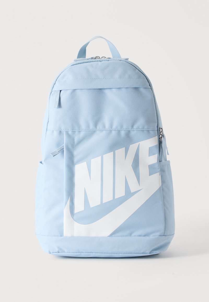 Φωτεινό γαλάζιο σακίδιο πλάτης Nike με μεγάλο λευκό λογότυπο και τσέπες με φερμουάρ μπροστά και στα πλευρά, όρθιο σε μονόχρωμο φόντο.