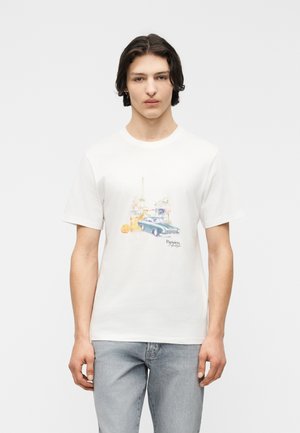 Ung mand iført en hvid T-shirt med en grafik af en vintagebil, en drink med appelsinskiver og teksten "Parisien lifestyle."