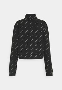 Sweat-shirt court noir à manches longues avec col montant et motif texte diagonal blanc répété "Calvin Klein Jeans" sur le devant et les manches.