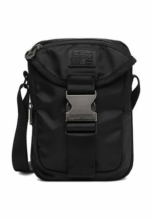 Černá crossbody taška G-Star Originals s nastavitelným popruhem, přední klopou zabezpečenou kovovou přezkou a značkovou nášivkou.
