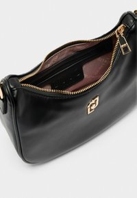 Borsa a mano in pelle nera con una trama liscia, dettagli in metallo dorato, chiusura a zip e fodera interna marchiata di colore rosa.
