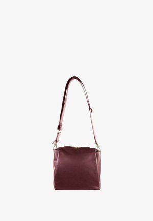 Borsa a mano in pelle bordeaux con chiusura superiore a zip, tracolla regolabile e texture liscia; presenta dettagli in metallo dorato.