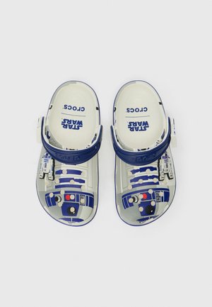 Børneslippers med blå og hvide Star Wars R2-D2 design og justerbare hælremme på en hvid baggrund.