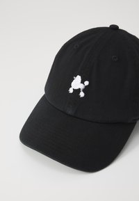 Căciulă de baseball neagră cu vârful curbat, din material textil. Are un design brodat alb al unui bichon pe față.