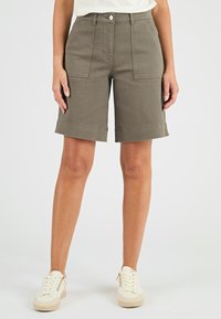 Pantaloni corti color kaki realizzati in misto cotone, con vita alta, due tasche frontali e risvolti. Abbinati a sneaker bianche.