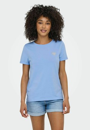 T-shirt en coton bleu clair avec un col rond, des manches courtes et un petit motif de cœur pailleté sur la poitrine gauche. Associé à un short en denim.