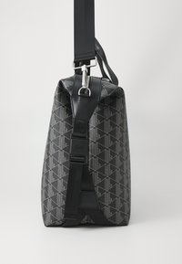 Black geometric patterned bag with a textured finish, featuring a sturdy black strap and metallic hardware on top.