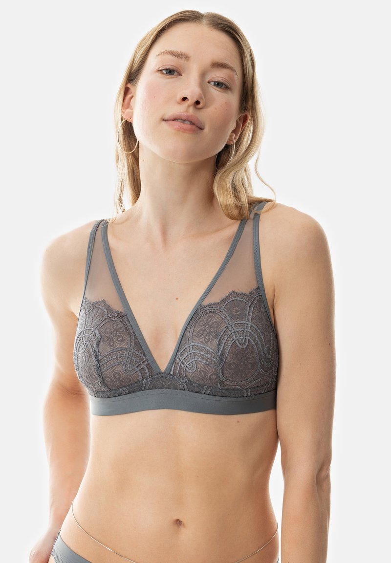 Gray lace bralette featuring a V-neck, sheer mesh details, adjustable straps, and a soft band. Intricate floral patterns throughout.