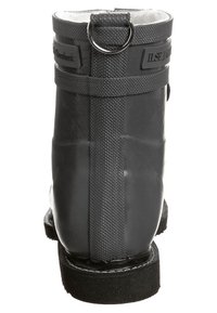 Zwarte rubberen enkelboot met een gladde afwerking, een achterste tab met een metalen ring en een gewatteerde zijklep voor eenvoudig aan- en uittrekken.