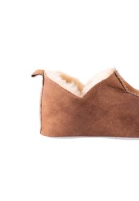 Chausson en suède marron avec une douce doublure en laine beige, design profil bas et un léger talon courbé. Aucun fermoir ni motif visible.