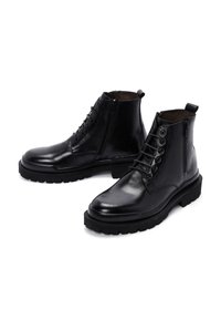 Botas de cuero negras con un acabado liso, que presentan un diseño con cordones, cremallera lateral y suela de goma resistente. Diseñadas para la durabilidad y la comodidad.