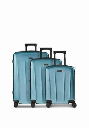 Drei blaue Hartschalenkoffer mit schwarzen Teleskopgriffen und vier Spinner-Rollen, von groß bis klein auf einem weißen Hintergrund angeordnet.