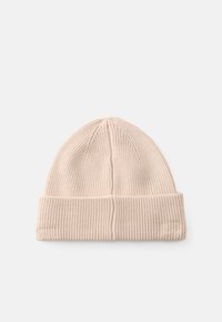 Gorro de punto en un color beis claro, con textura acanalada, puño doblado y parte superior redondeada con un sutil detalle de costura.