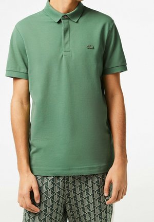 Zielona koszulka polo z kołnierzykiem i zapinaniem na dwa guziki. Posiada haftowane logo na piersi. Wykonana z miękkiego, teksturowanego materiału bawełnianego.