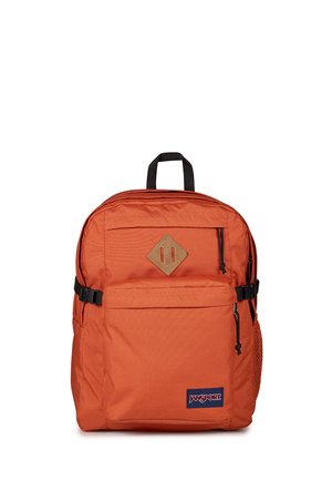 Orange Jansport rygsæk med sort håndtag, forreste lynlåslomme, sidelomme i net og brun diamantformet patch på ens hvid baggrund.