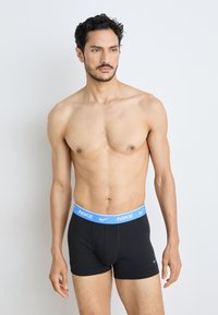 Schwarze Baumwoll-Boxershorts mit einem himmelblauen Nike-Logo-Bund. Das Design zeichnet sich durch eine körpernahe Passform und eine glatte Textur aus.