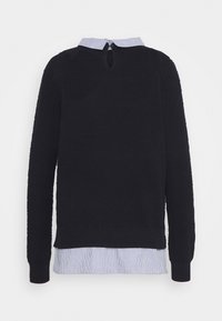 Czarny, teksturowany sweter z długim rękawem nałożony na biało-niebieską koszulę w paski z zapięciem na guziki i otworem z tyłu.