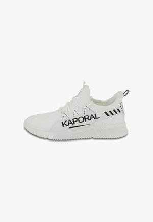 Zapatilla deportiva blanca con parte superior de tejido, que presenta la marca "KAPORAL" en negro, acentos texturizados y un lazo en el talón para facilitar el uso.