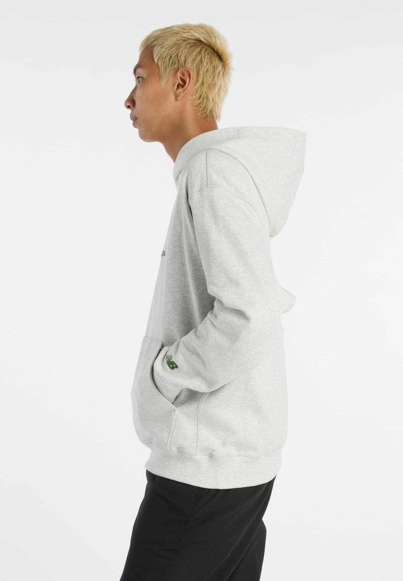 Grauer Hoodie aus weichem Stoff, mit einer großen Kapuze, vorderer Tasche und grünen Logo-Elementen. Geschmeidige Textur mit lässiger Passform.