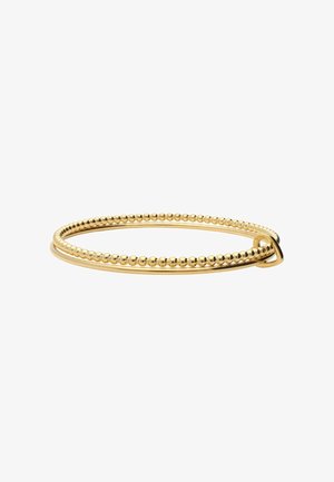 Bracciale doppio a forma di bangle in oro con un anello liscio e uno con perline, collegati da un piccolo anello d'oro su sfondo bianco.
