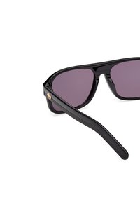 Black sunglasses with a glossy finish, purple lenses, and a sleek design. Includes a gold accent logo on the side.