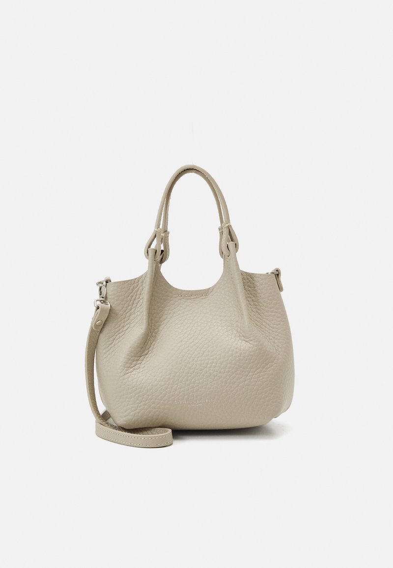 Beige Handtasche aus Leder mit texturierter Oberfläche, doppelten Griffen und einem abnehmbaren Schulterriemen, die eine runde Form und ein minimalistisches Design aufweist.