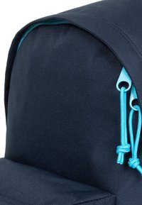 Zaino in tessuto blu navy con parte superiore arrotondata, cerniere turchesi e accenti coordinati con cordoncino nella tasca anteriore.