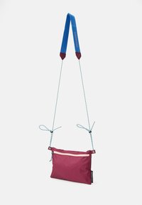 Sac compact bordeaux avec une poche zippée à l'avant, une bandoulière bleue amovible et des cordons de tirage bleu clair ; fabriqué en matériau durable.