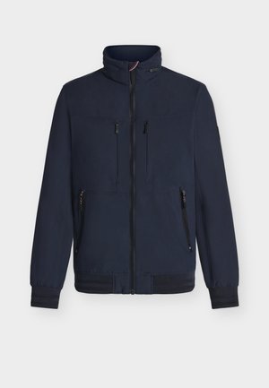 Chaqueta azul marino de tela suave, con cremallera frontal, dos bolsillos en el pecho, dos bolsillos laterales y puños y dobladillo acanalados.