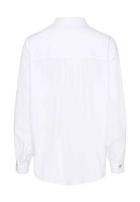 Chemise blanche à manches longues avec une pièce de dos, des poignets à boutons et un ourlet droit, vue de dos sur fond uni.