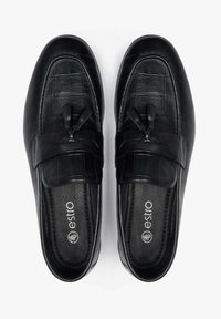 Zwarte leren loafers met een krokodillenpatroon, voorzien van een decoratieve band en kwastjes. Gladde textuur en geplooide inlegzolen voor comfort.