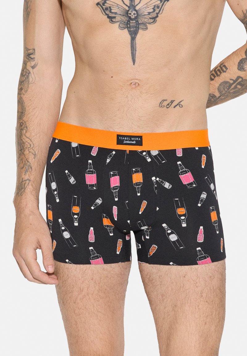 Bóxers negros con cinturilla naranja y un patrón de botellas ilustradas en rosa y naranja, llevados por un modelo masculino tatuado desde la cintura hasta la mitad del muslo.