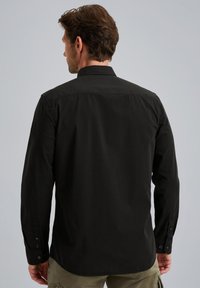 Schwarzes Langarmhemd mit einem Knopfkragen, gerade geschnittenem Saum und geknöpften Manschetten. Glattes Baumwollgewebe mit minimalen Details.